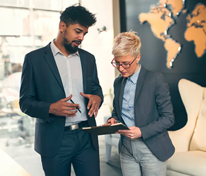 Hombre y mujer revisando las estrategias internacionales para una compañía